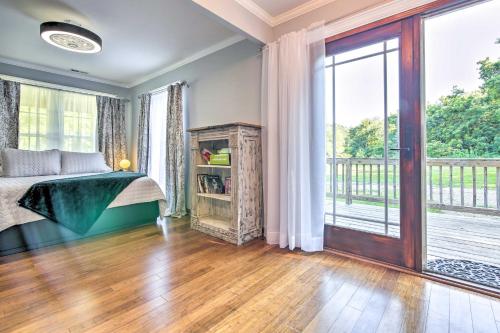 Peaceful Kansas Cottage with Wraparound Deck!的一间卧室设有一张床和一个大窗户