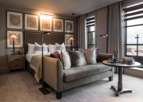 曼彻斯特Dakota Manchester的一间卧室配有一张床、一张沙发和一张桌子