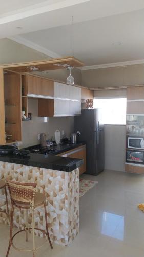 卡莫辛Casa de temporada Camocim的厨房配有柜台和冰箱。