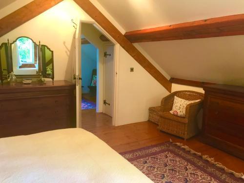 克雷迪顿St Michaels Coach House的一间卧室配有一张床、镜子和椅子
