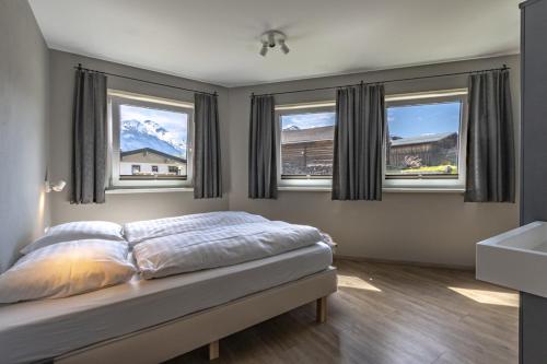 卡普伦Haus am Bach的一间卧室配有床、两个窗户和一个水槽
