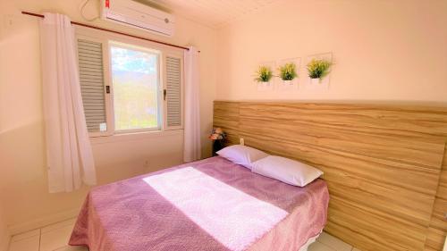 乌巴图巴De Bem K Vida的一间卧室设有一张床和一个窗口