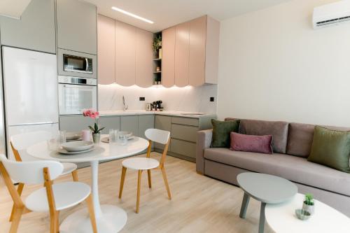 亚历山德鲁波利斯Magico Suites City Heart Luxury Appartments的厨房以及带桌子和沙发的客厅。