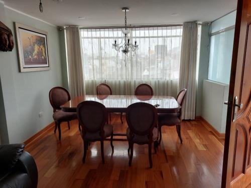 利马Departamentos Las Lilas Surco Lima的一间带桌椅和窗户的用餐室