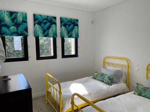 帕福斯Paphos luxury contemporary villa的客房设有两张床、一张桌子和窗户。