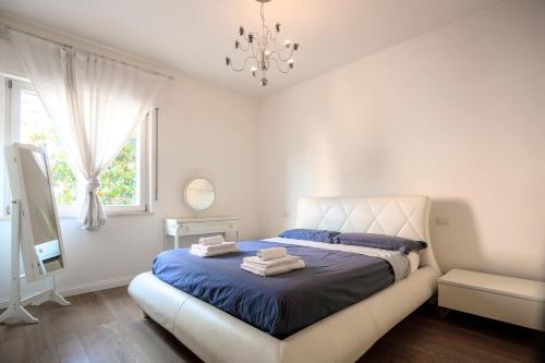 基亚拉瓦莱L'OASI DELLA PACE - Confortevole e vicino a tutto的一间卧室配有一张带蓝色床单和吊灯的床。