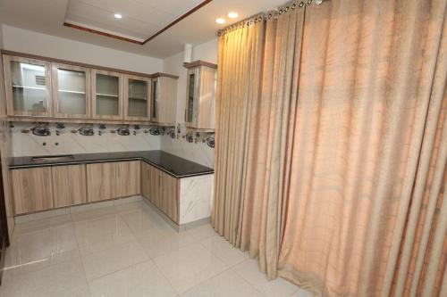 拉合尔Grand Swiss Hotel&Apartment Lahore的厨房配有木制橱柜和浴帘
