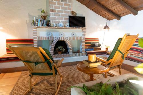 格拉纳迪利亚德亚沃纳坎普拉尼娅卡萨乡村酒店的客厅设有壁炉和椅子