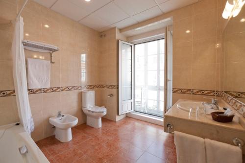 布尔戈斯北伦敦酒店的浴室配有卫生间、浴缸和水槽。