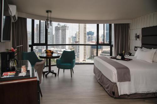 巴拿马城巴拿马城广场酒店的酒店客房,配有一张床和一张桌子及椅子