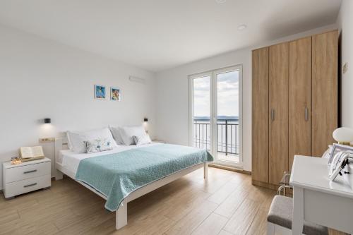 麦米科Luxurious apartments Bona fide的白色的卧室设有床和大窗户