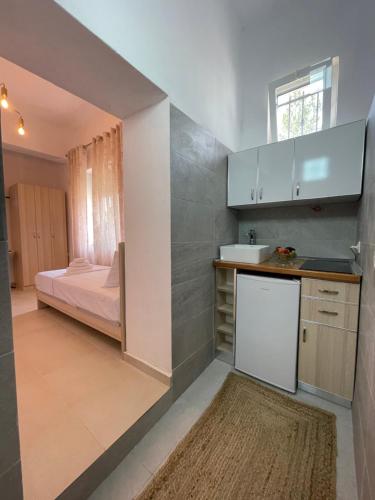 ÇorovodëSkrapari Studio Apartment的一个带水槽的厨房和一张位于客房内的床