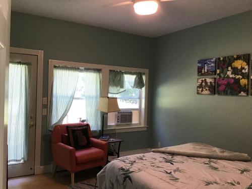 罗克波特Adorable Garden Suite的卧室配有床、椅子和窗户。