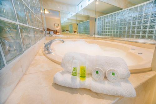 利马米拉弗洛雷斯科隆酒店的浴室配有带毛巾和水槽的浴缸。