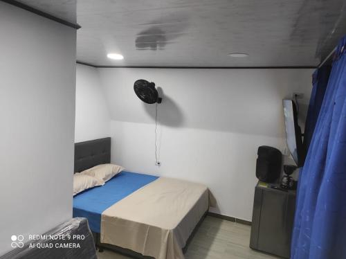 梅尔加Cabañas Mirador La Roca的卧室配有一张床,墙上配有风扇