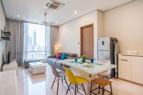 吉隆坡Soho Suites KLCC by GuestHouse的厨房以及带桌子和黄色椅子的客厅。