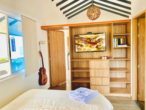 佛罗里达布兰卡Ruitoque Apartamento Campestre Maravillosa Vista的一间卧室配有一张床和吉他