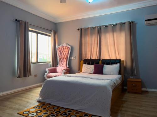 ApenkwaT’s place的一间卧室配有一张床和一张粉红色的椅子