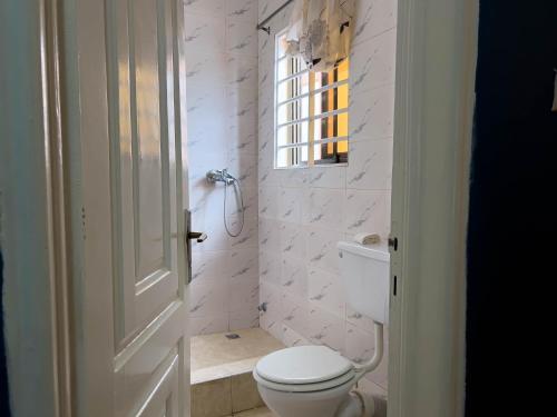 ApenkwaT’s place的白色的浴室设有卫生间和窗户。