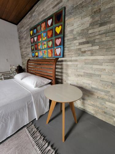 皮帕Buddha Suítes的卧室配有一张床和一张桌子,旁边是墙壁