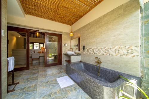 绥和市Sao Mai Beach Resort的客房内的浴室设有大浴缸
