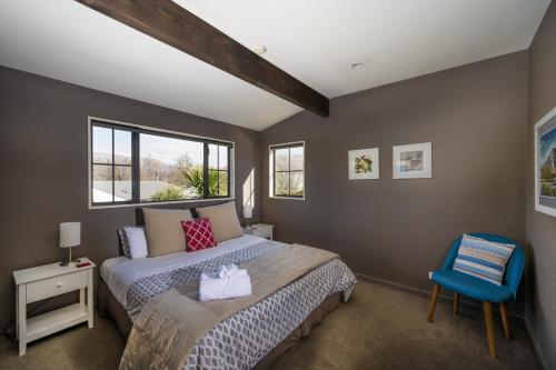 瓦纳卡Criffel Peak View Bed and Breakfast的一间卧室配有一张床和一张蓝色椅子