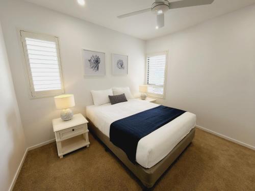 玛志洛沙丘棉树公寓的一间白色卧室,配有床和2个窗户
