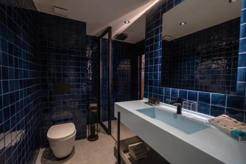 伊斯坦布尔Zimmer Bosphorus Hotel的蓝色瓷砖浴室设有卫生间和水槽