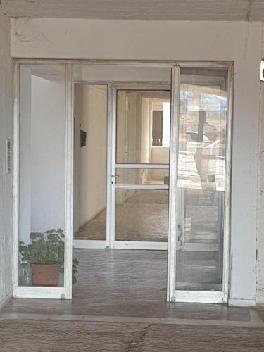 阿纳维索斯Christy's House Anavissos / Ανάβυσσος的一间房间里一扇种植植物的敞开的门