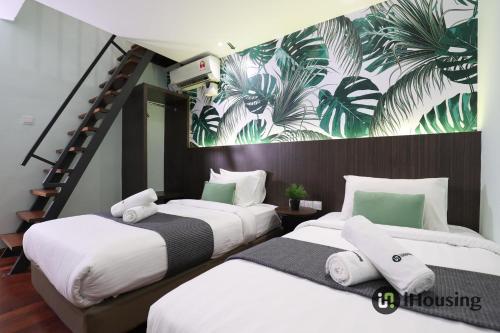 马六甲Trevor Hotel Malacca Town By I Housing的墙上壁画的房间里设有两张床