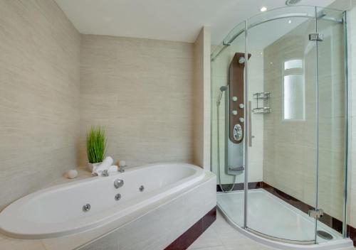 罗廷丁La Villa的带浴缸和玻璃淋浴间的浴室。