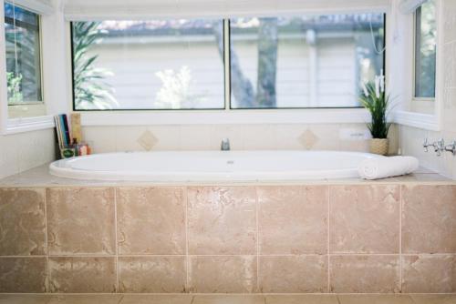 谭伯连山Shambala Eco Retreat的带浴缸的浴室和窗户