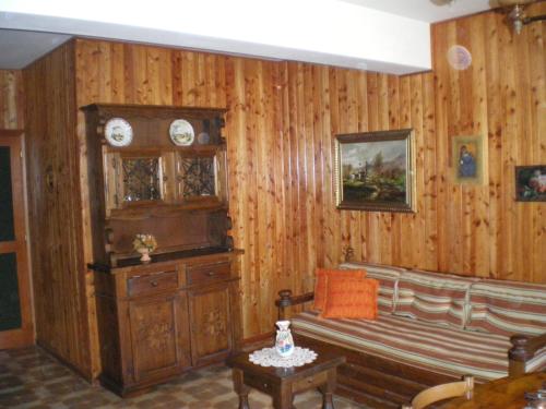 斯坎诺Residence I Comignoli的客厅设有木墙、长凳和时钟