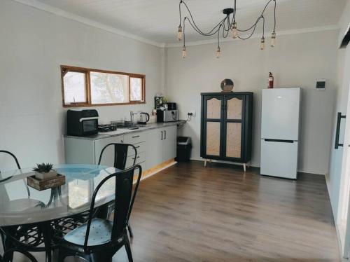 鲁德普特River Cabin的厨房配有桌子和白色冰箱。