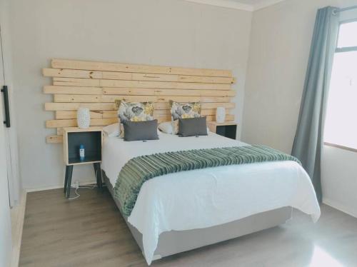 鲁德普特River Cabin的一间卧室配有一张大床和木制床头板