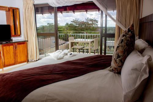 卡萨内Wild View Resort的一间卧室设有一张大床和一个阳台