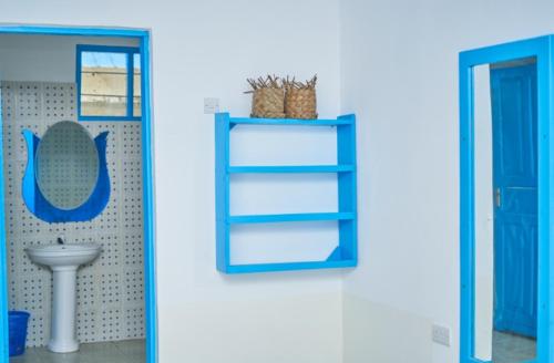 帕杰Beach House Paje的浴室设有蓝色架子和水槽