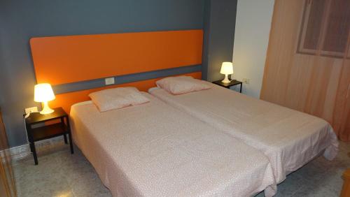 塔马达斯特Vivienda Vacacional "La Sanjora"的卧室配有白色的床和两盏灯。