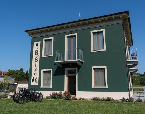 Mombello MonferratoB & Bike di Ristorante Italia的一座绿色建筑,前面停放着自行车
