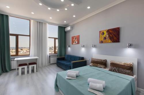 巴库Leyla Apartments 2的一间卧室配有蓝色的床和蓝色的沙发