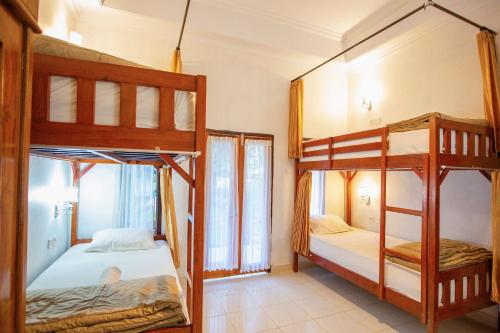 珀尼达岛Kamasanti Hostel的一间带两张双层床的卧室和一个阳台