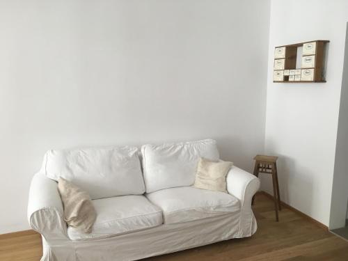 格蒙登Apartment zur schönen Sophie的白色的房间里设有一张白色的沙发,配有桌子