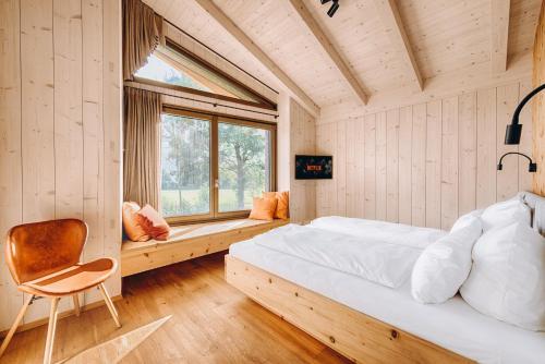 加尔米施-帕滕基兴Chalet Dreitorspitz - Riverside的卧室配有床、椅子和窗户。