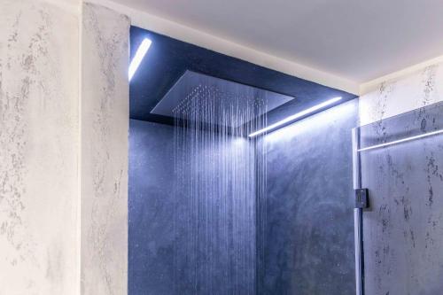 米兰VIA DELLA SPIGA N50 - Luxury Loft in the Heart of the Fashion District的带淋浴的浴室和蓝色的墙壁