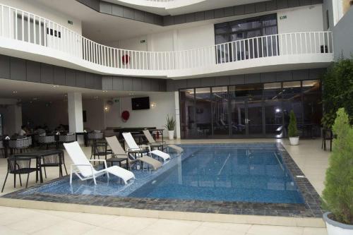 达喀尔AXIL HÔTEL的酒店设有带桌椅的游泳池