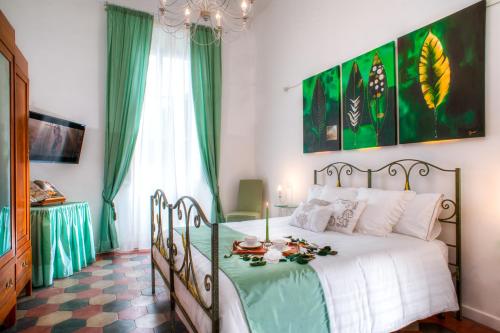 罗马竞技场浪漫公寓的一间卧室配有一张带绿色和白色棉被的床