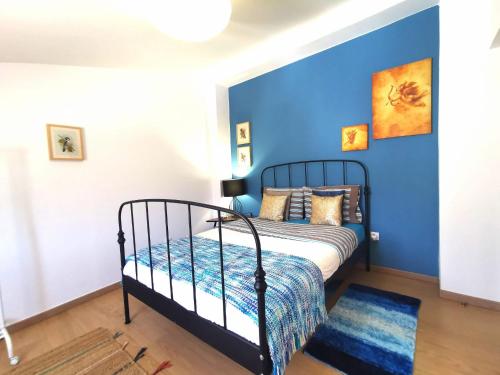 西尔韦斯Silves Country Room的一间卧室配有一张蓝色墙壁的床