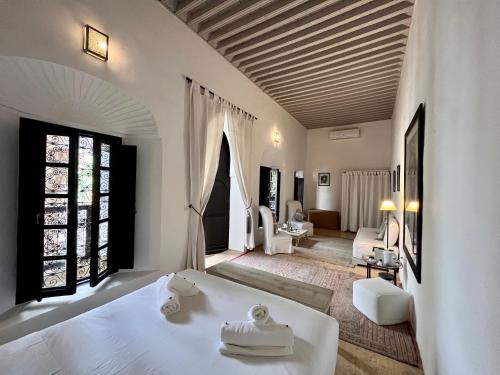 马拉喀什RIAD ENNAFOURA BOUTIQUE HOTEL的一间带白色床的卧室和一间客厅