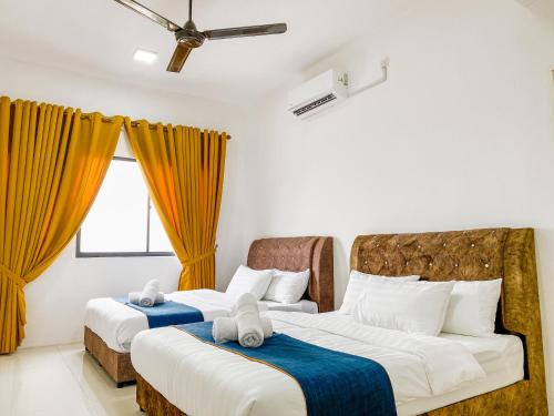 瓜拉丁加奴Tamu Place 3-Bedroom Serviced Apartment with Pool的配有黄色窗帘的客房内的两张床