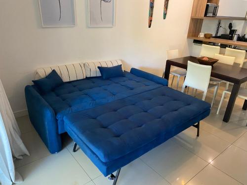 埃斯特角城Green Park的客厅配有一张蓝色的沙发,配有一张桌子